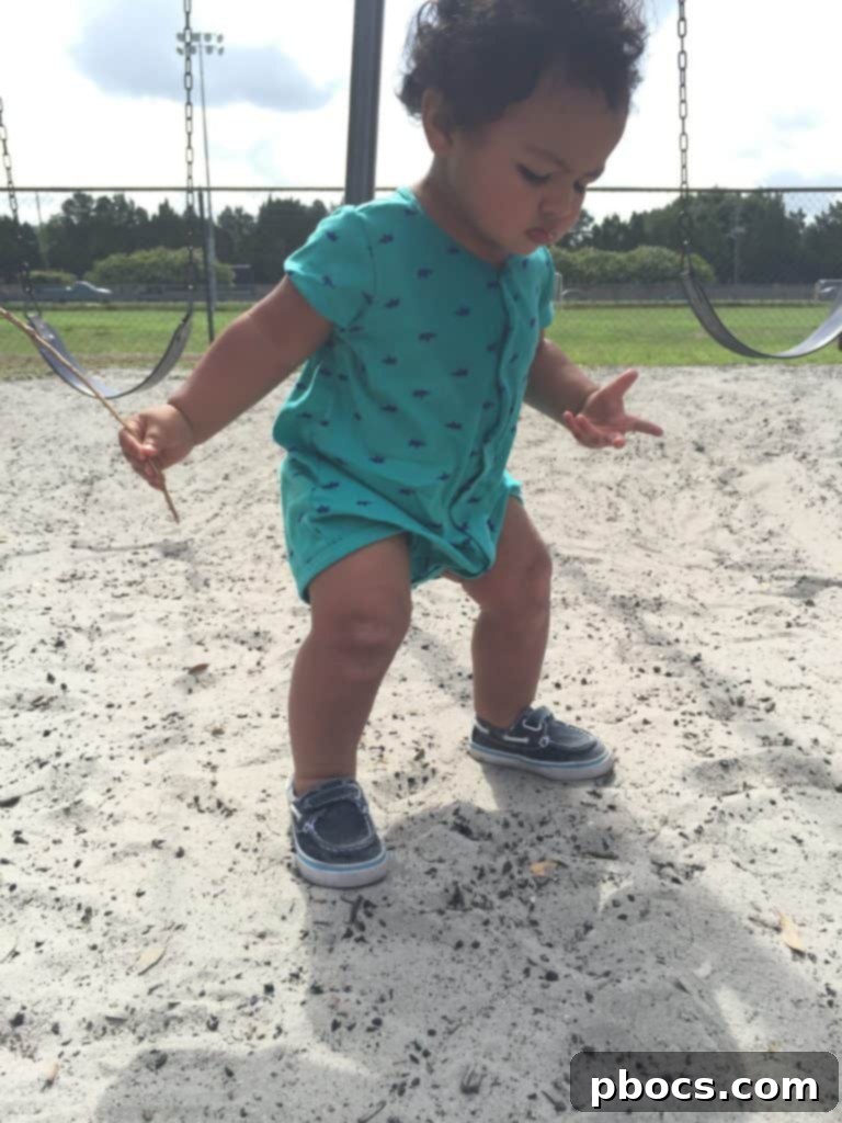 Close-up of Joseph's intense focus as he plays with his branch at the park, embodying childhood imagination.