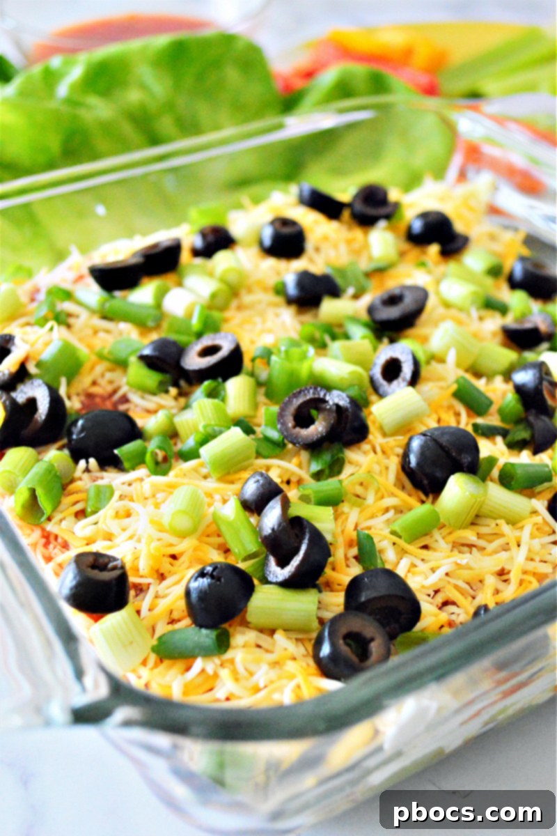 A serving of Low-Carb 7 Layer Taco Dip with dippers, ready for a party.