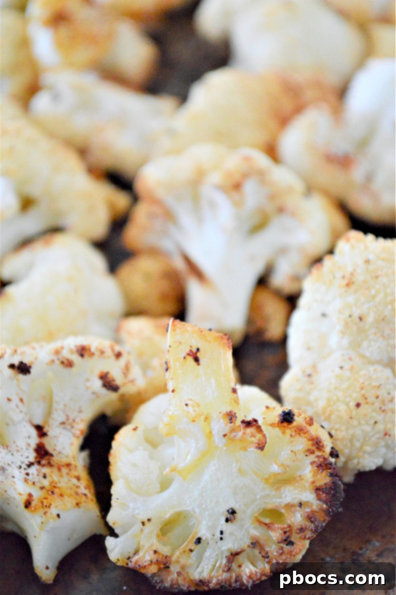 Cauliflower roasting in the oven, halfway through cooking time.