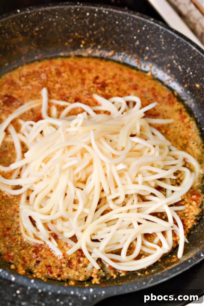 Effortless Keto Shrimp Scampi 14 Adding Palmini noodles to scampi sauce