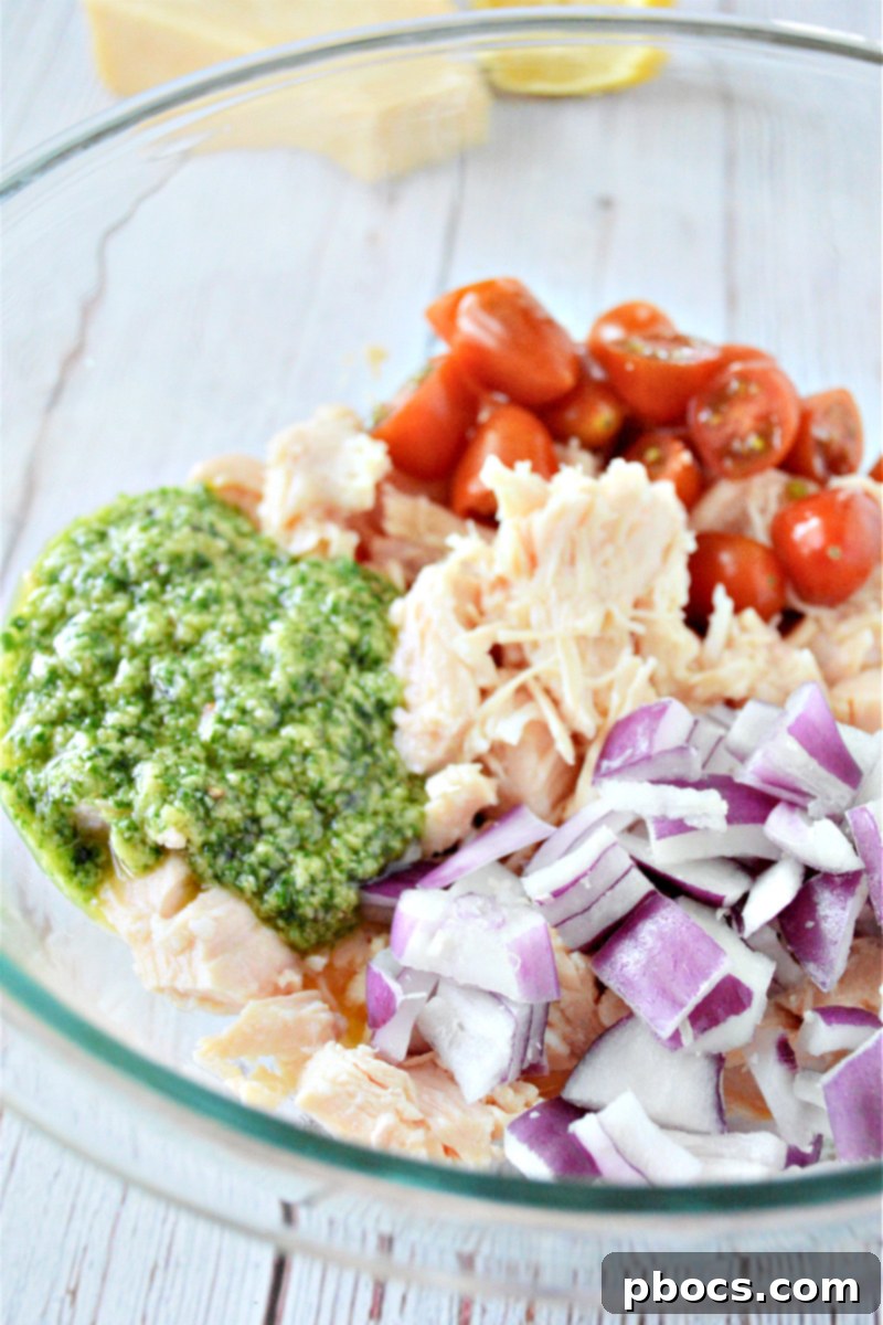 Mediterranean Low Carb Pesto Chicken Salad 12 Combining canned chicken, pesto, onion, and tomatoes in a bowl