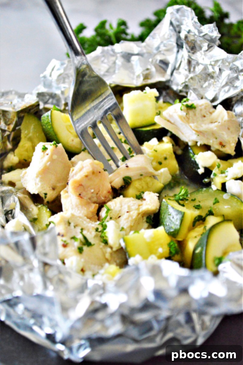 Finished Garlic Butter Chicken Foil Packets garnished with parsley and feta cheese