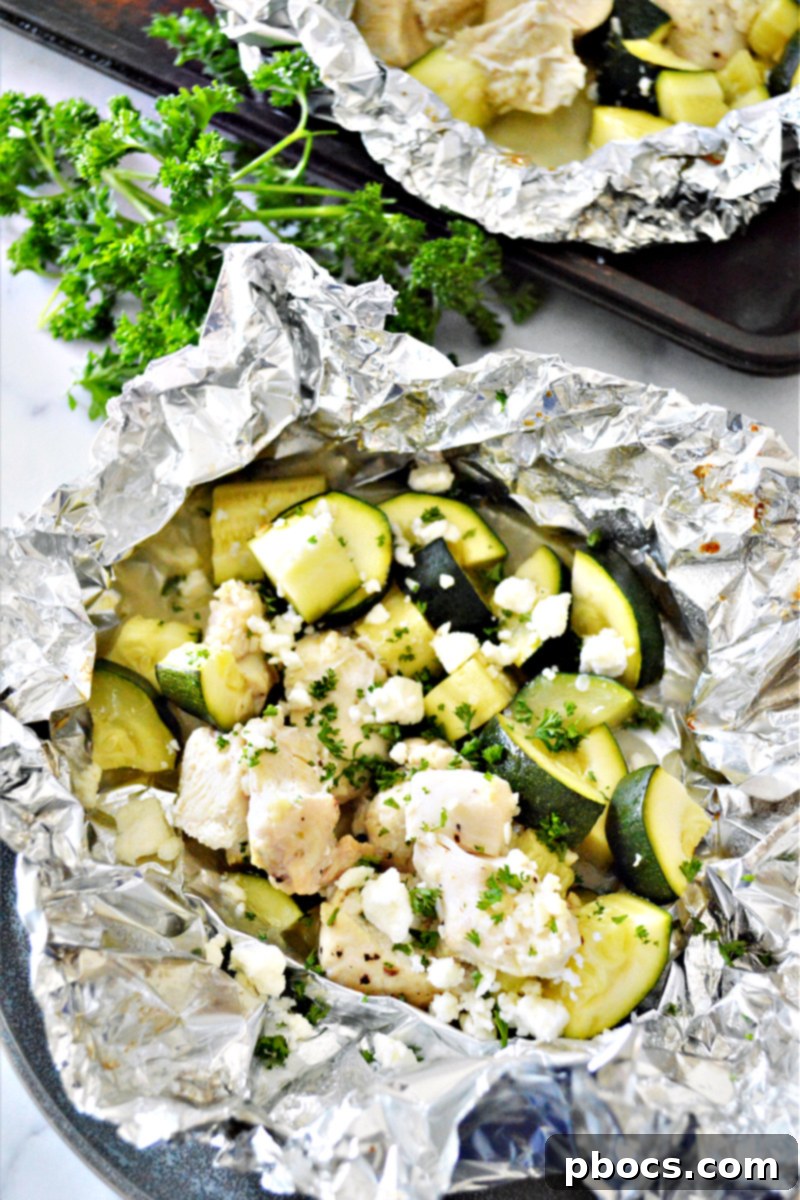 Close-up of cooked Garlic Butter Chicken Foil Packets with fresh parsley and feta