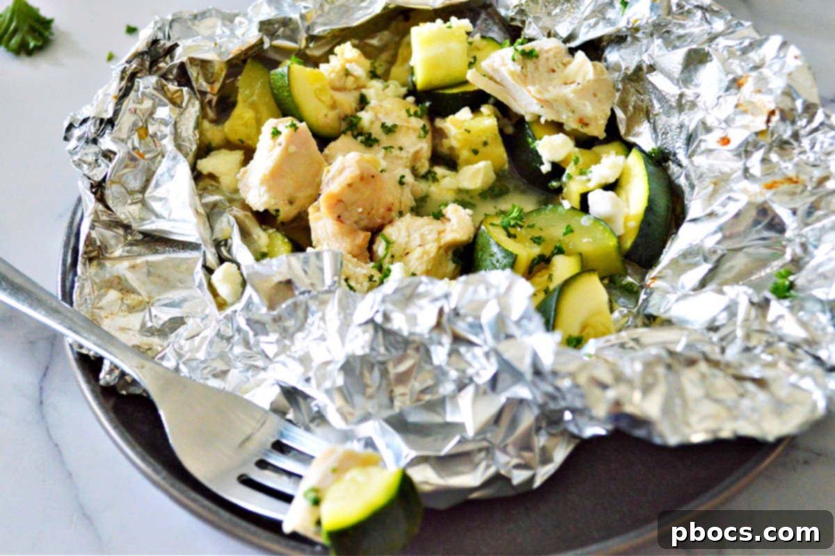 Garlic Butter Chicken Foil Packets cooking over a campfire, perfect for keto camping