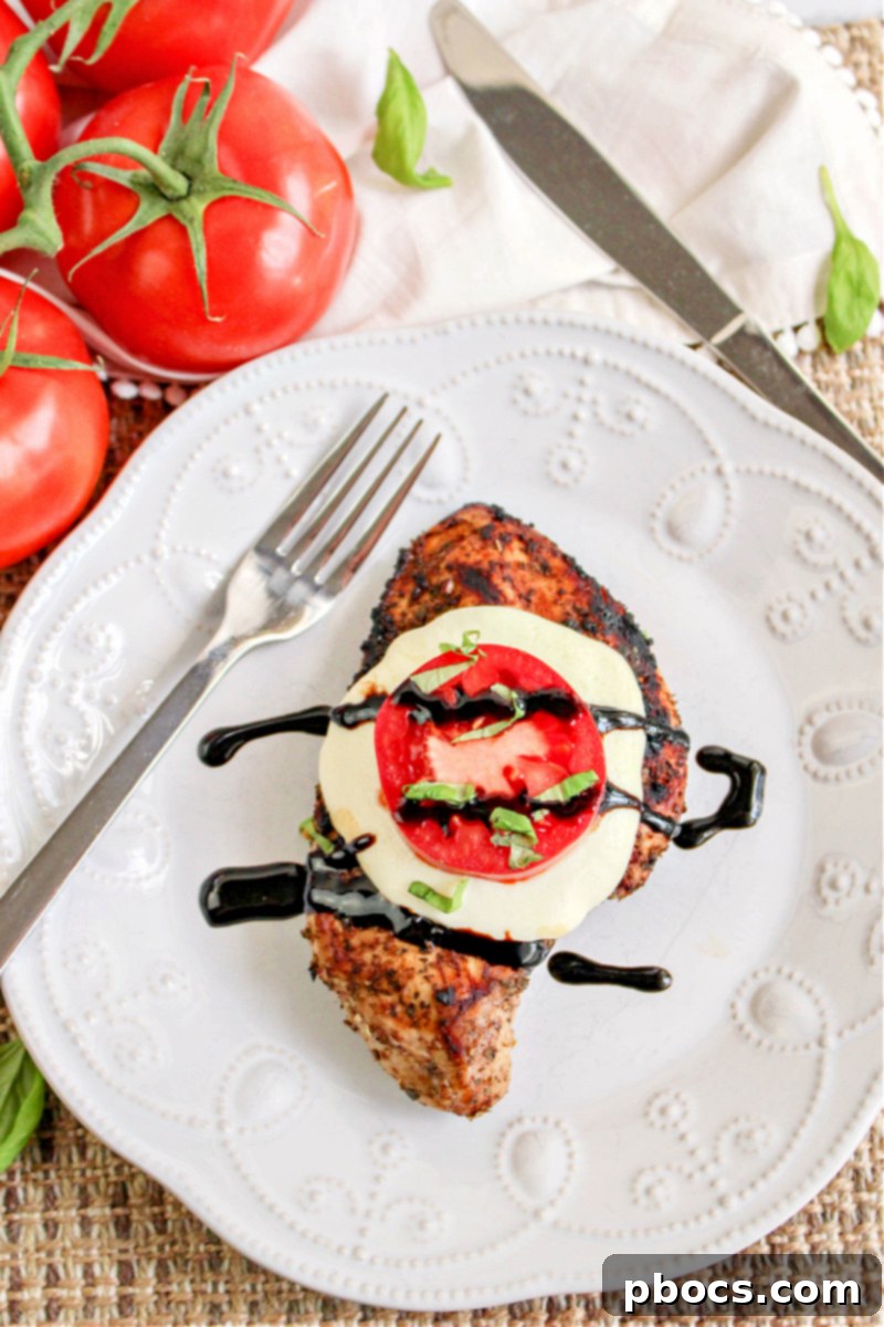 Keto Caprese Chicken Bake 2 Keto Caprese Chicken on a plate, garnished with fresh basil and balsamic glaze