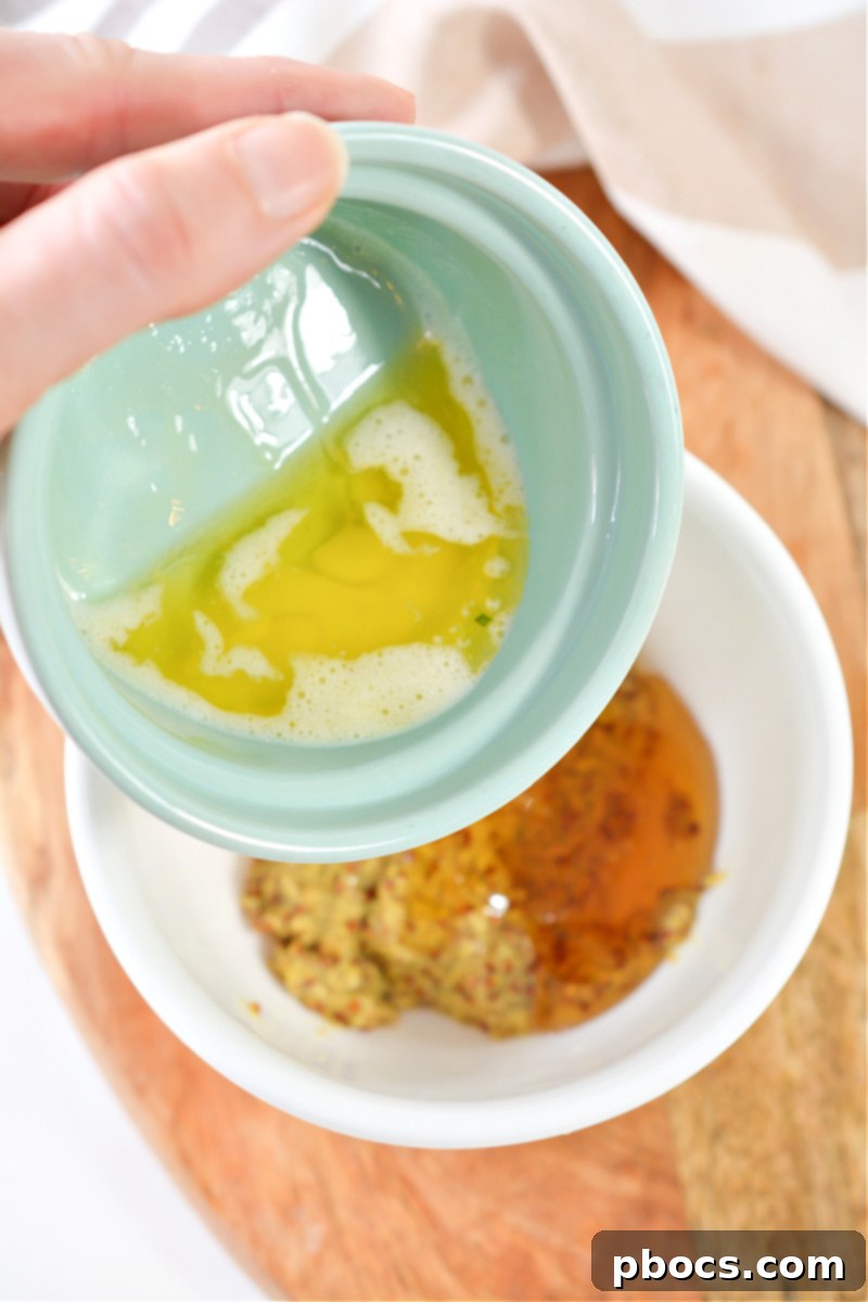 Whisking together the ingredients for the keto honey mustard sauce in a bowl.