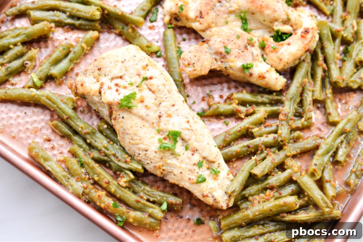 Keto Honey Mustard Chicken and green beans baking on a sheet pan, showing the vibrant colors.
