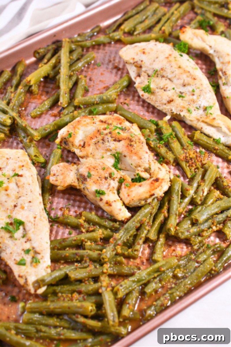 Cooked Keto Honey Mustard Chicken with tender green beans, ready to be served from the sheet pan.