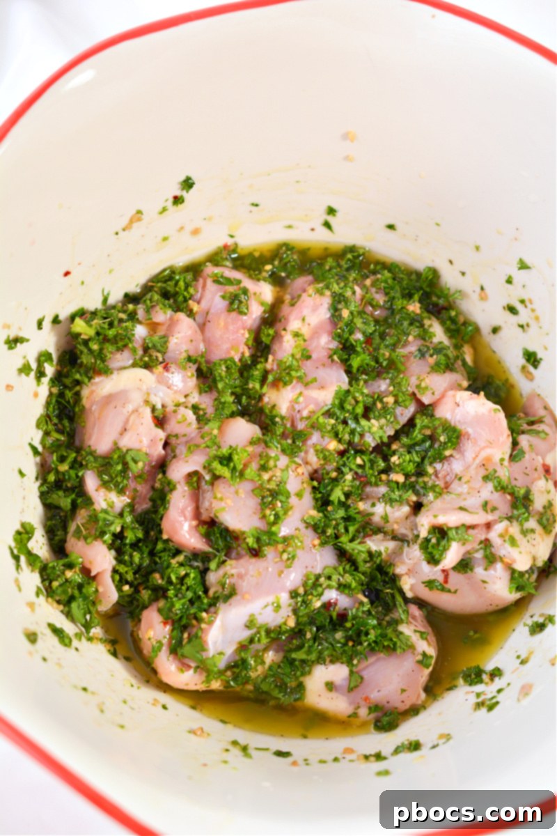 Chicken thighs being tossed in the chimichurri marinade