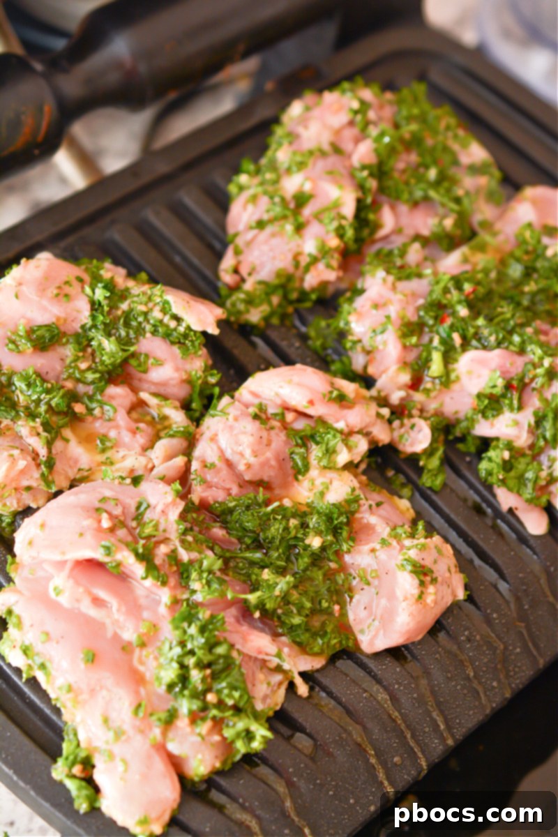 Chicken thighs marinating in a covered bowl in the refrigerator
