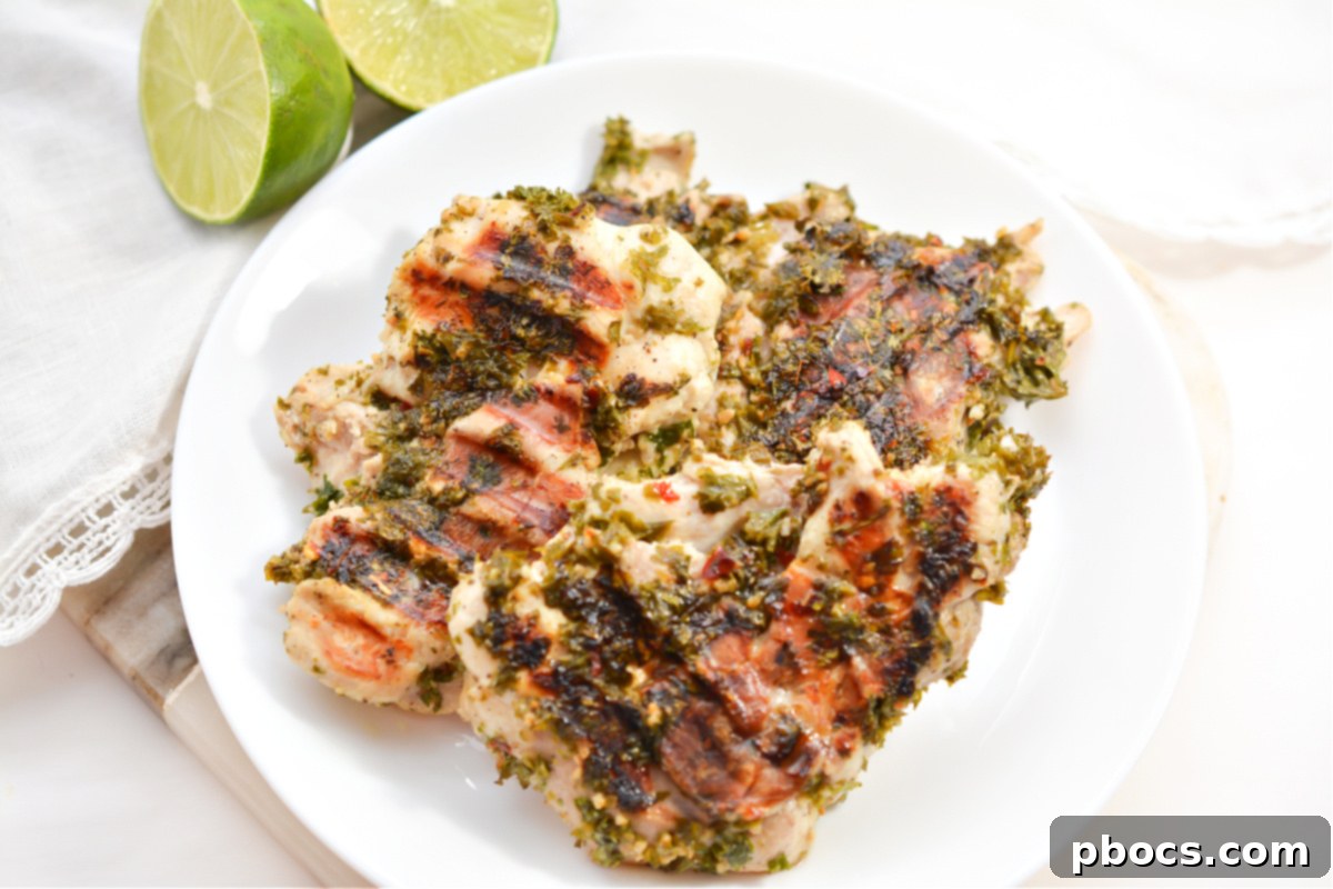 Grilled Keto Chimichurri Chicken thighs on a plate, garnished with fresh parsley