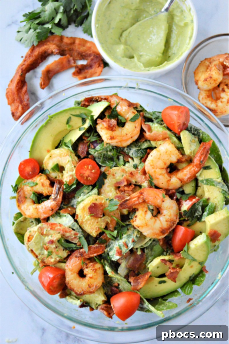 A versatile shrimp avocado spinach salad, easily customizable with various proteins and toppings.