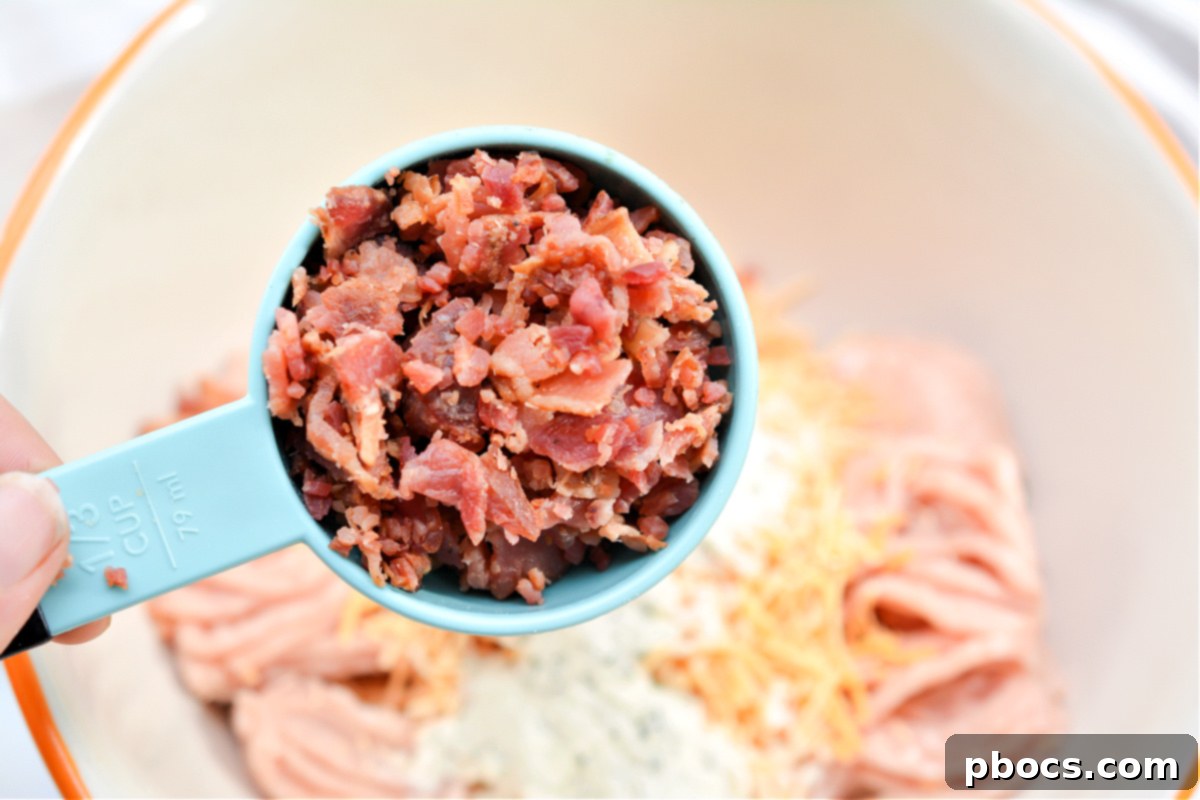Ingredients for Keto Cheddar Ranch Chicken Burgers being mixed thoroughly in a bowl