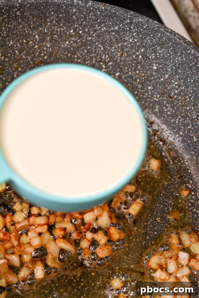 Cooked Keto Cheddar Ranch Chicken Burgers being tossed in the creamy BBQ sauce
