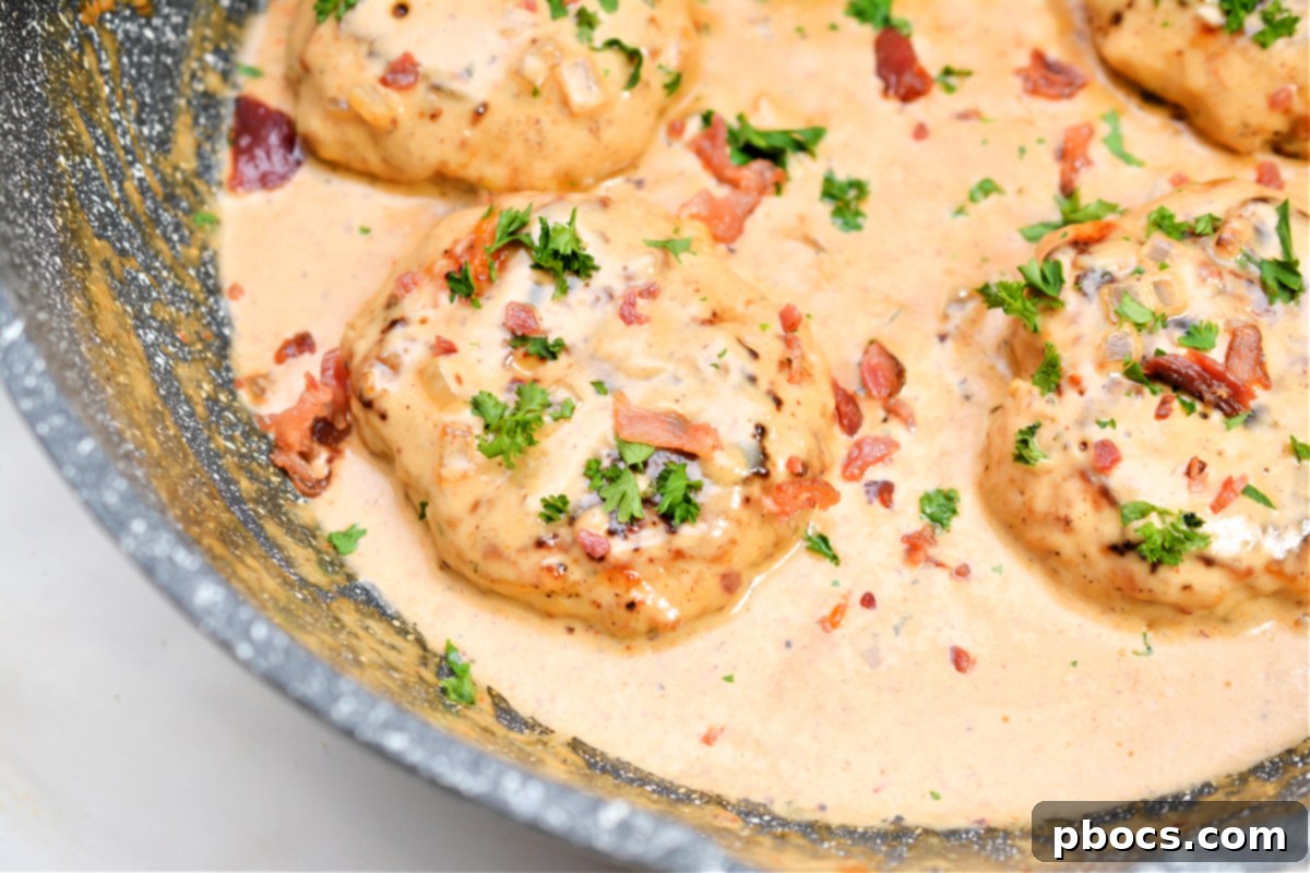 Keto Cheddar Ranch Chicken Burgers smothered in BBQ Cream Sauce in a skillet
