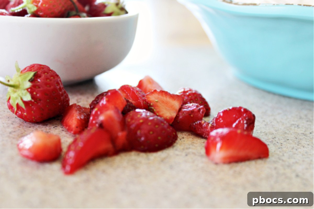 Folding strawberries into cream cheese mixture for cheesecake layer