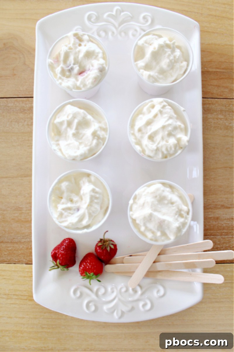 Creamy Keto Strawberry Cheesecake Popsicles with fresh strawberries