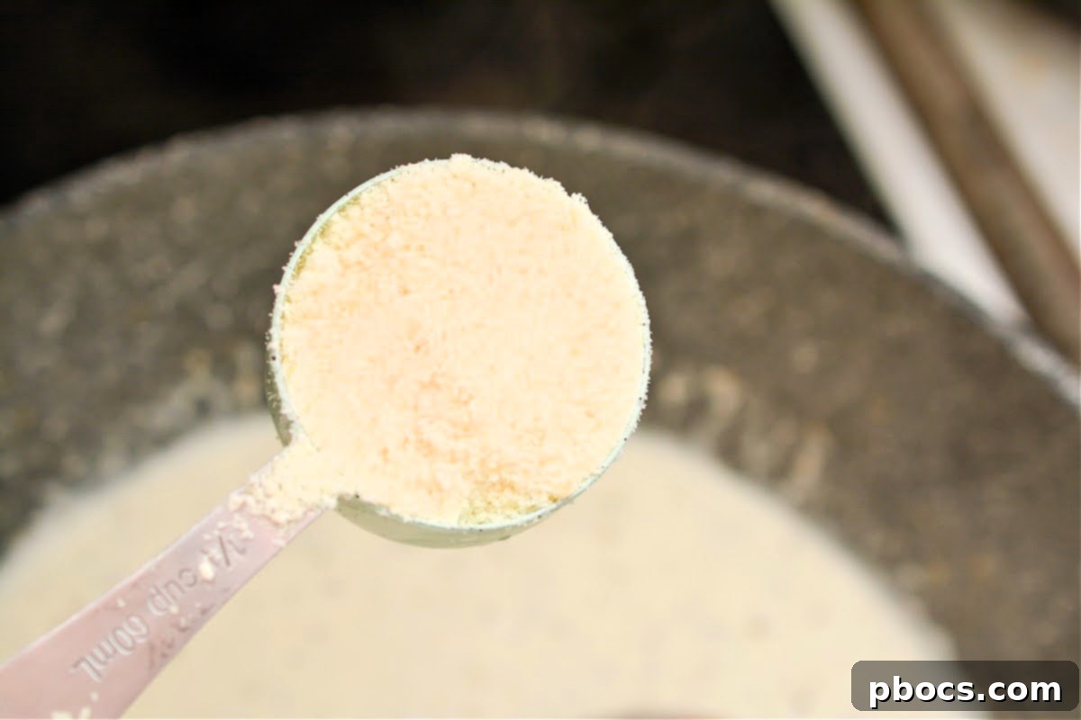 Ultimate Creamy Keto Garlic Shrimp 16 Adding Parmesan cheese and fresh spinach to the creamy sauce