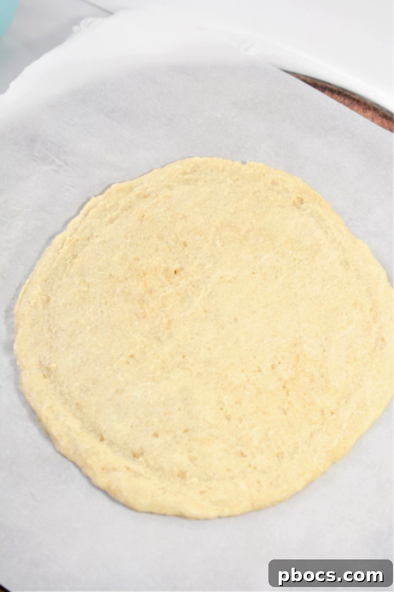 Shaping keto fruit pizza crust on parchment paper