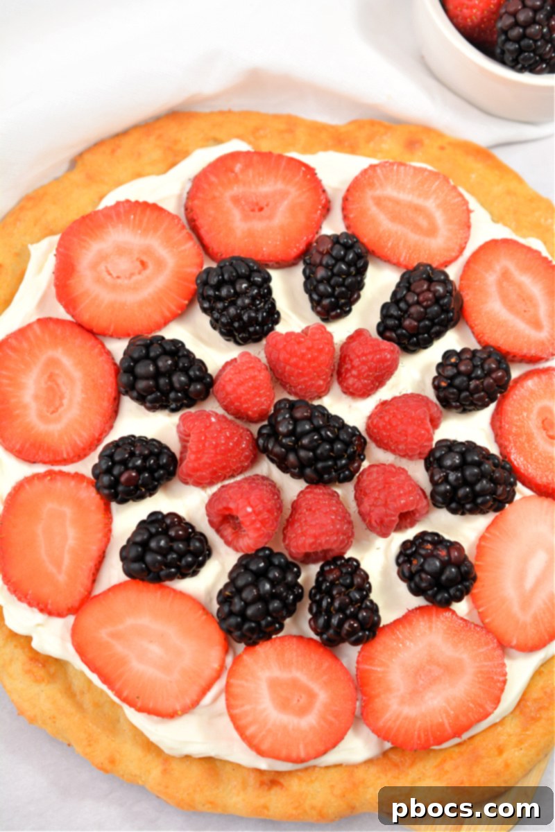Decorating keto fruit pizza with fresh berries