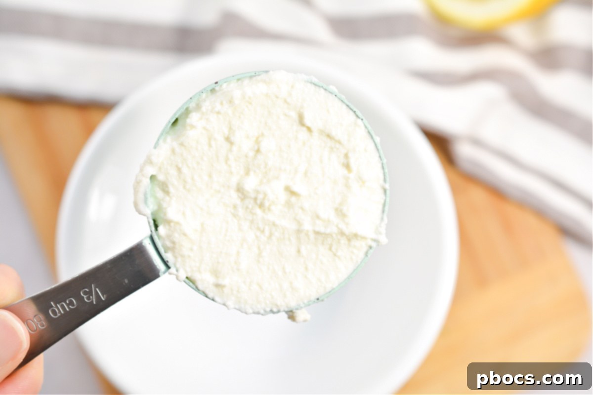 Mixing ricotta cheese with lemon juice and seasoning in a bowl.