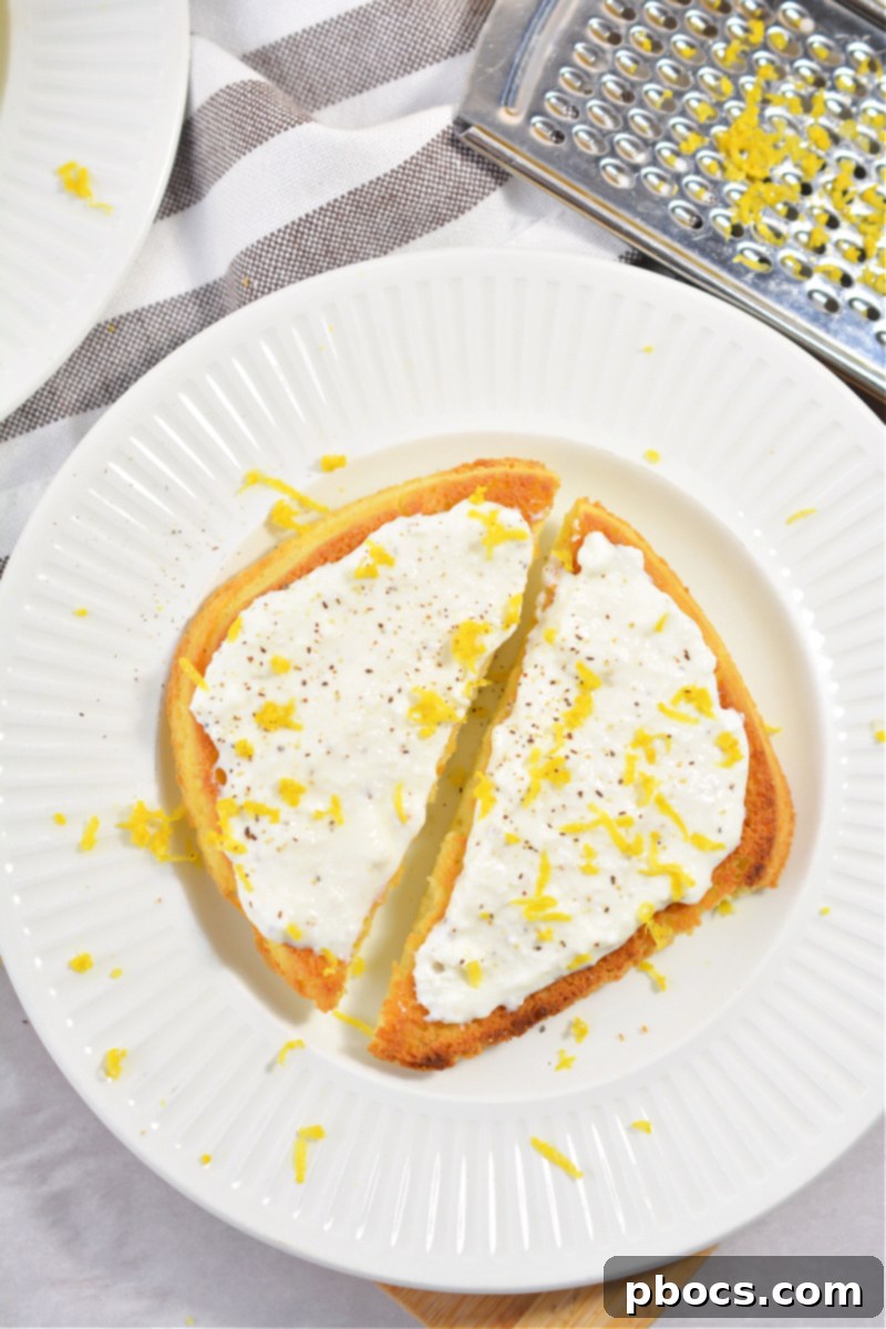 A close-up of creamy ricotta cheese being spread on keto toast.
