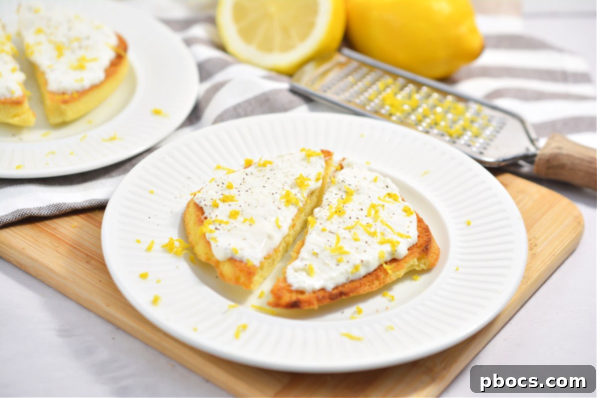 Two slices of Keto Ricotta Toast garnished with fresh lemon zest and a sprinkle of black pepper.
