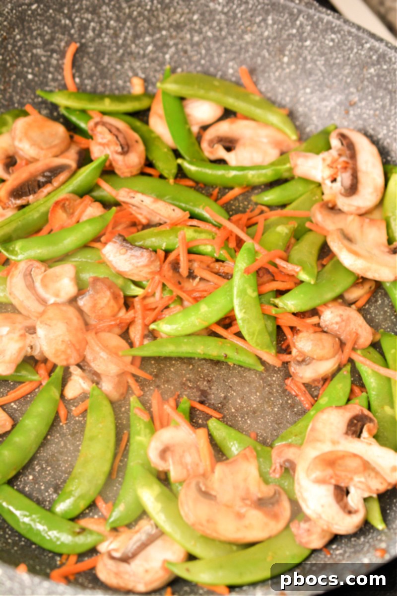 Keto Moo Goo Gai Pan Stir Fry 13 Step 5: Mushrooms, snap peas, and carrots softening in the skillet.