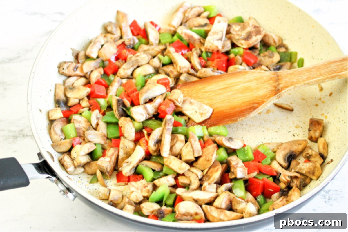 Savory Keto Veggie Morning Bake 12 Sautéed bell peppers and mushrooms in a skillet, ready to be added to the casserole dish