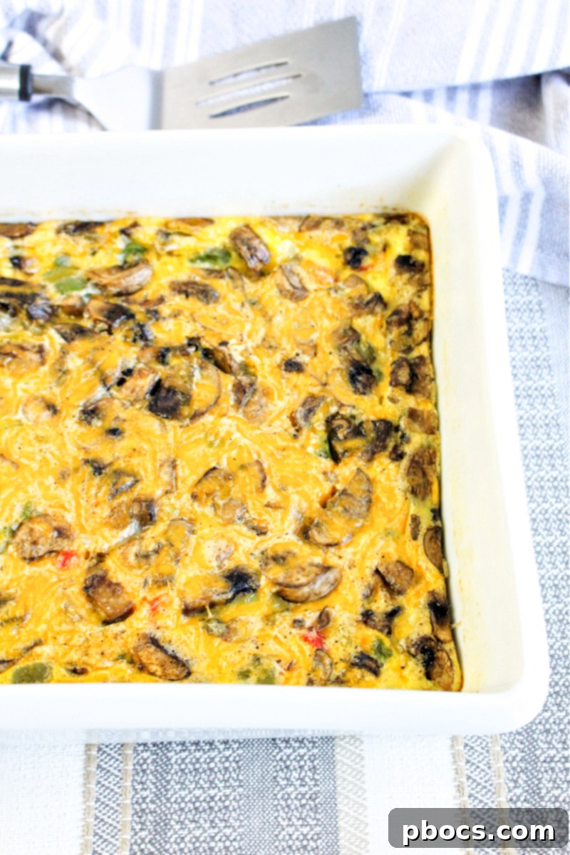 Savory Keto Veggie Morning Bake 15 The Keto Breakfast Bake in a casserole dish, with eggs poured over vegetables and topped with cheese, ready for baking