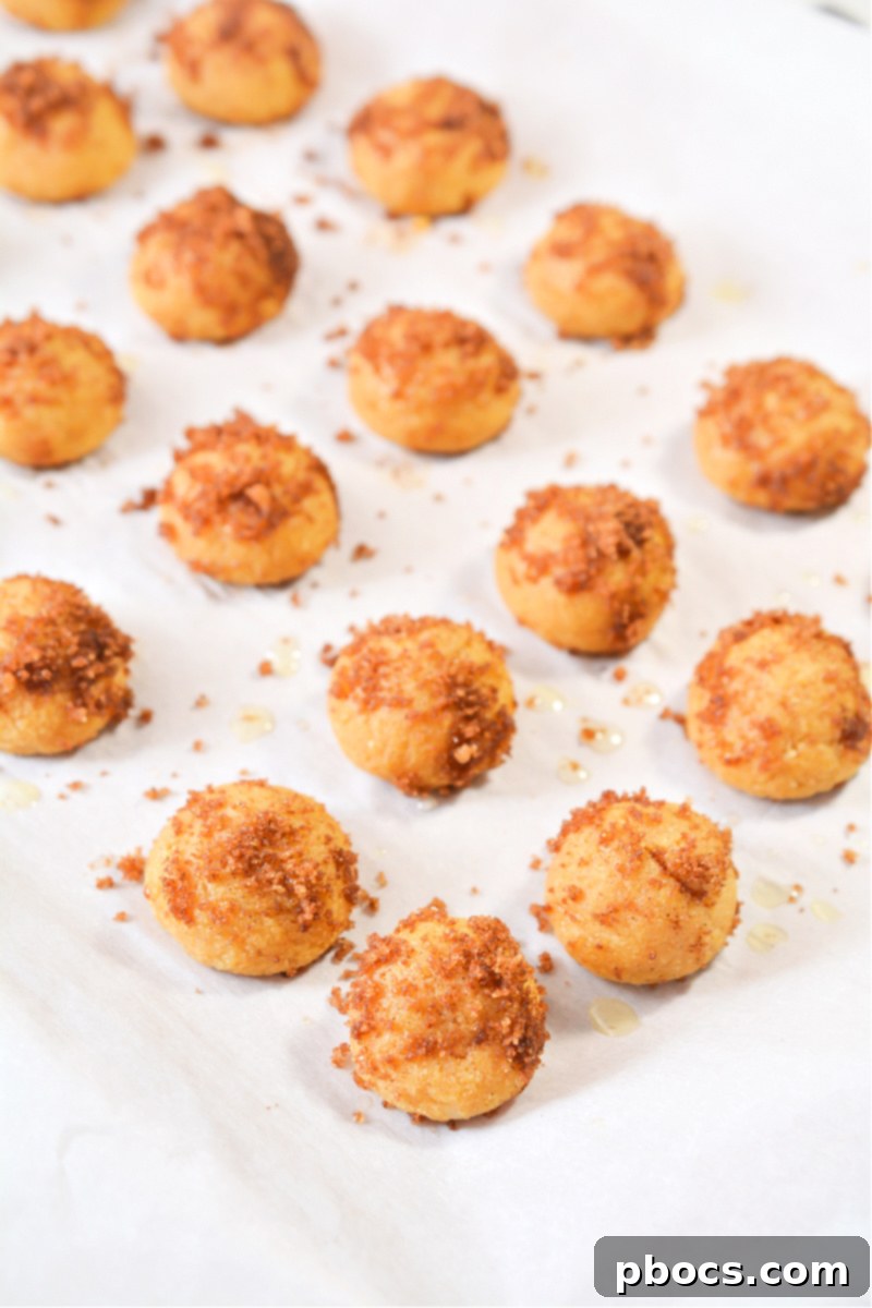 Coating Keto Pumpkin Spice Donut Holes in cinnamon sugar mixture