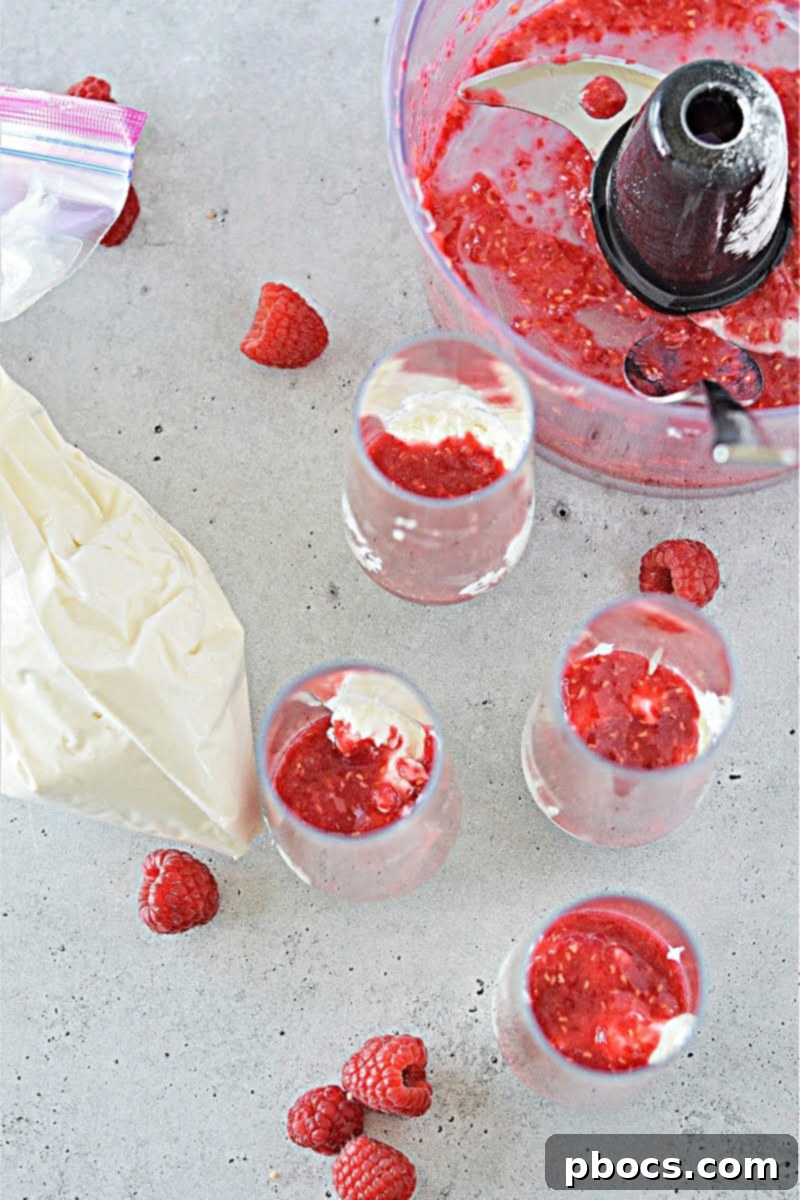 Layered Keto Cheesecake Fluff and raspberry sauce in a glass jar