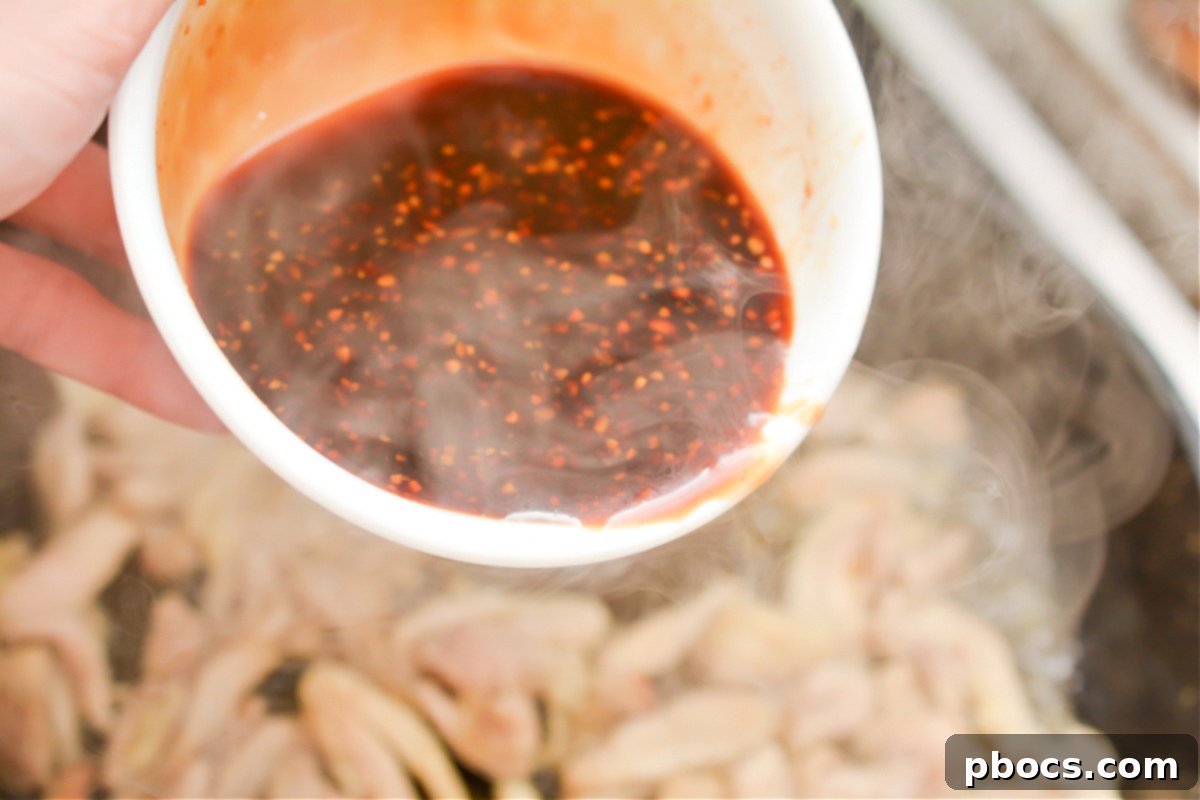 Sticky Keto Garlic Chicken simmering in the skillet, fully coated in its rich, thickened sauce.