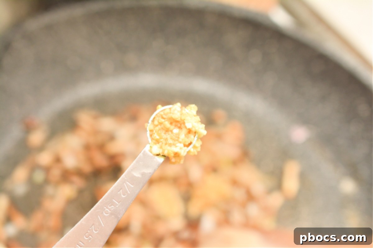 Adding garlic to sautéed mushrooms and shallots
