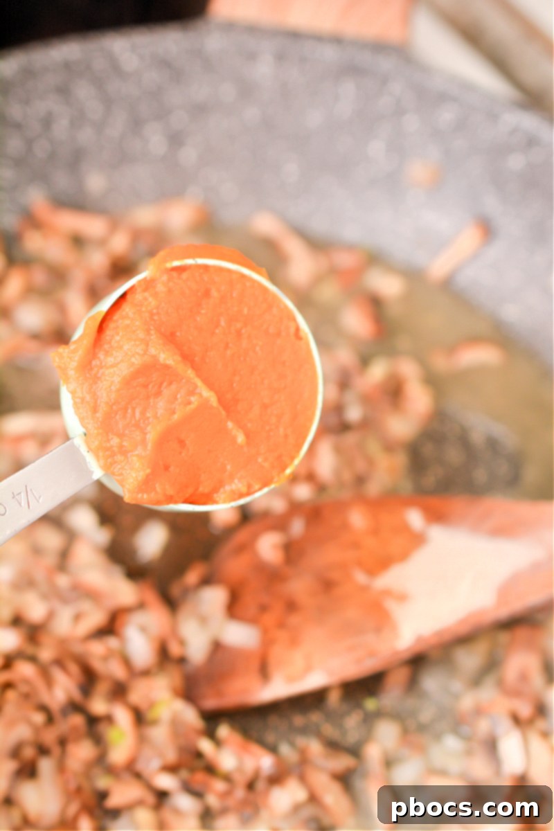 Adding pumpkin puree to the risotto sauce