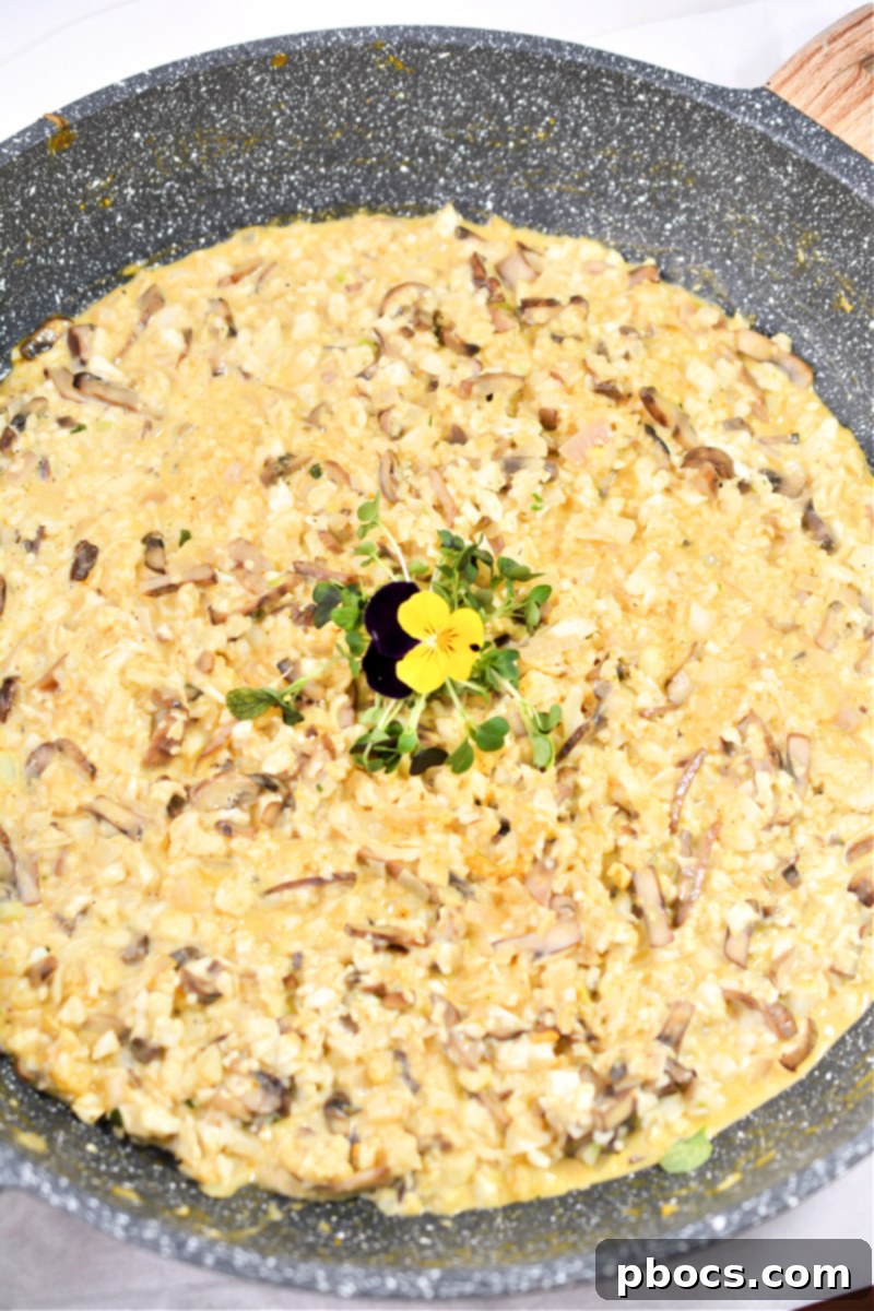 Mixing cauliflower rice into the creamy pumpkin sauce