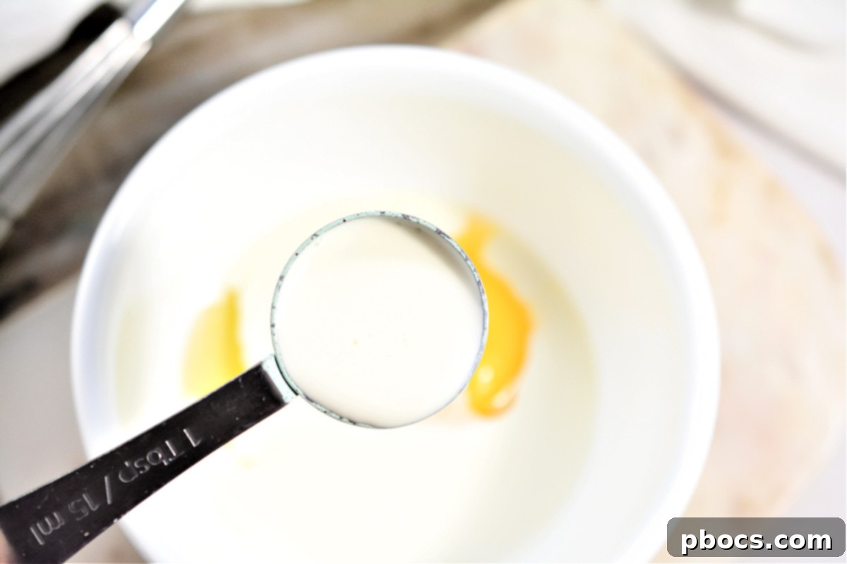 Keto Cordon Bleu Chicken Poppers 12 Whisked egg and heavy whipping cream mixture in a bowl.