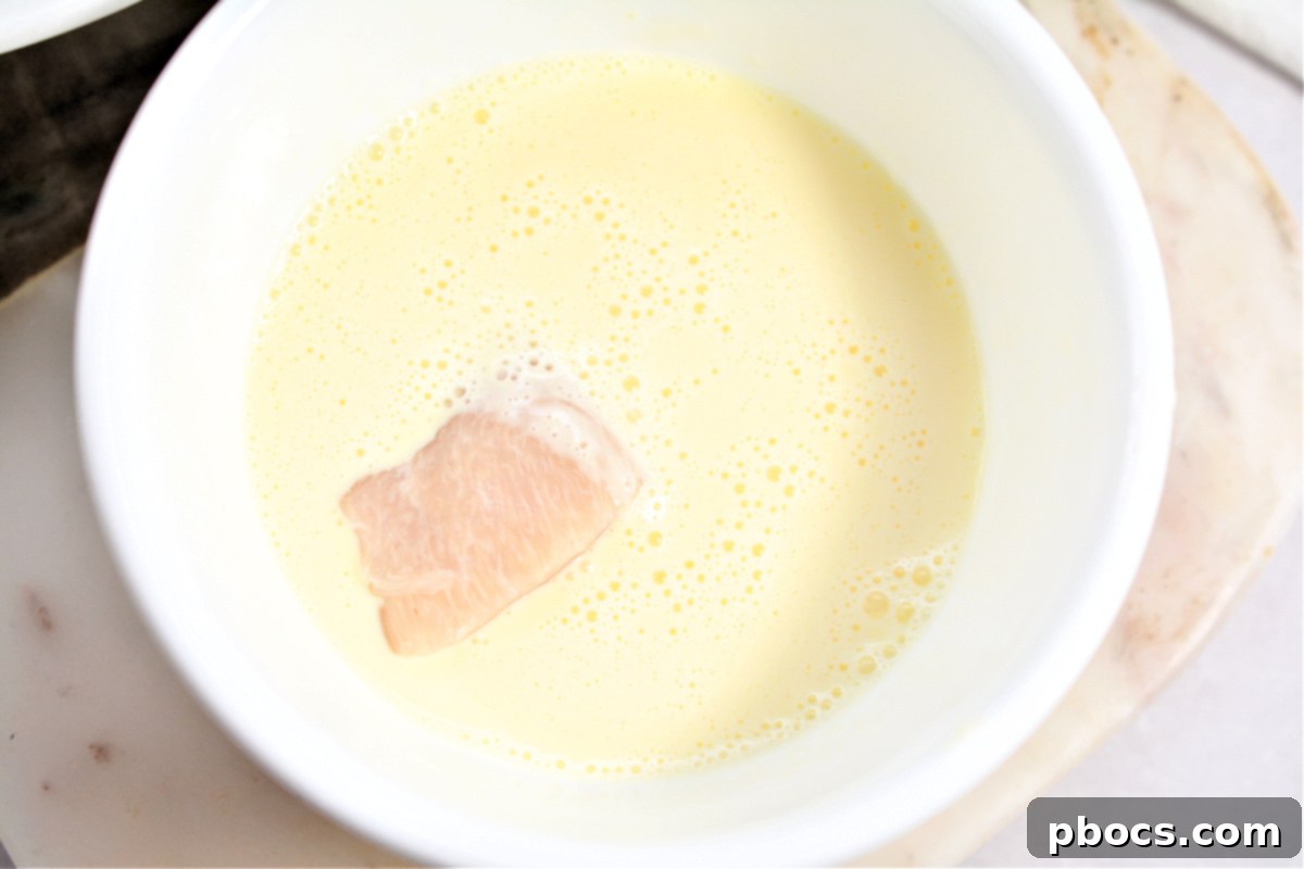 Keto Cordon Bleu Chicken Poppers 13 Dipping chicken chunks into the egg wash.