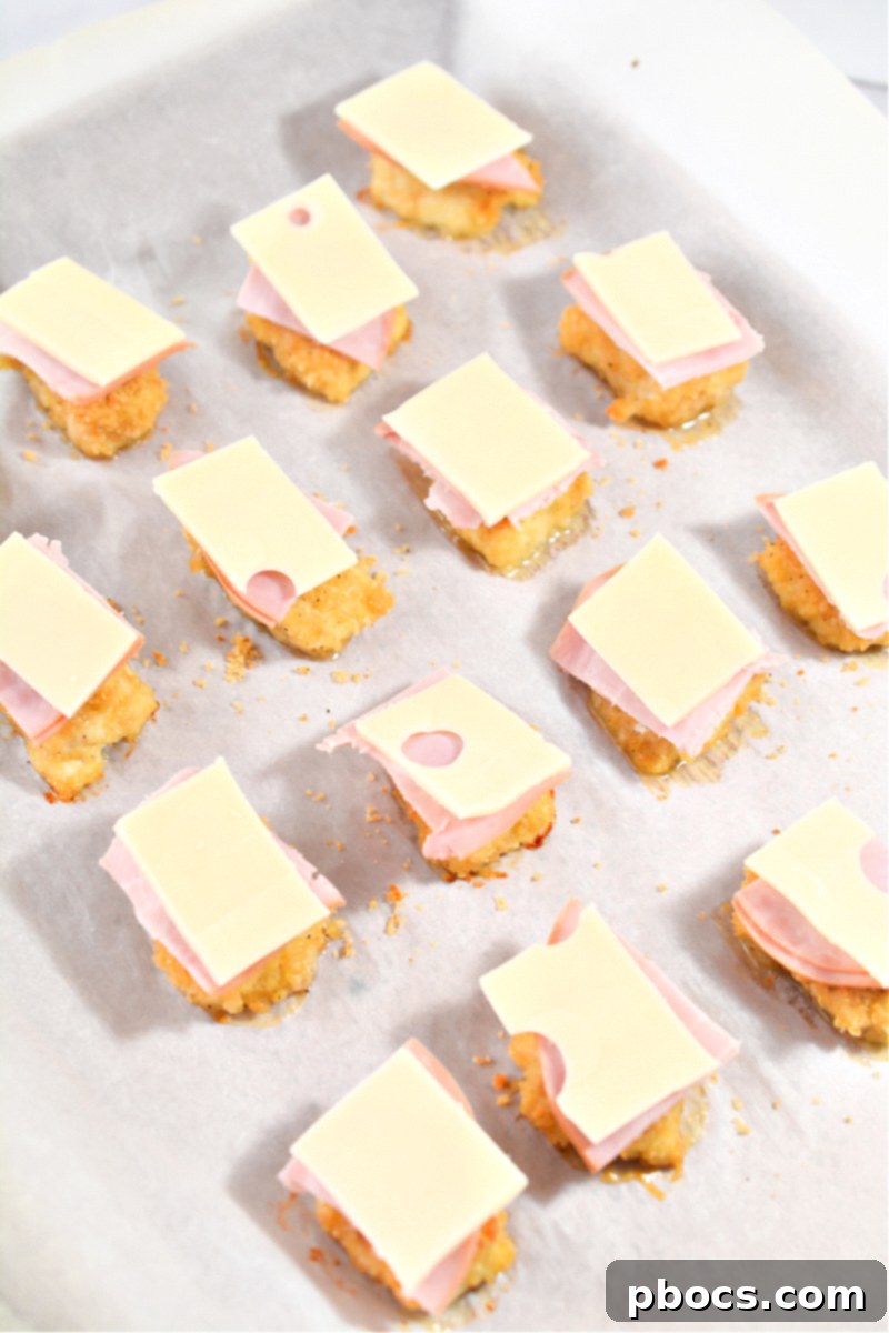 Keto Cordon Bleu Chicken Poppers 18 Adding Swiss cheese squares on top of ham and chicken.