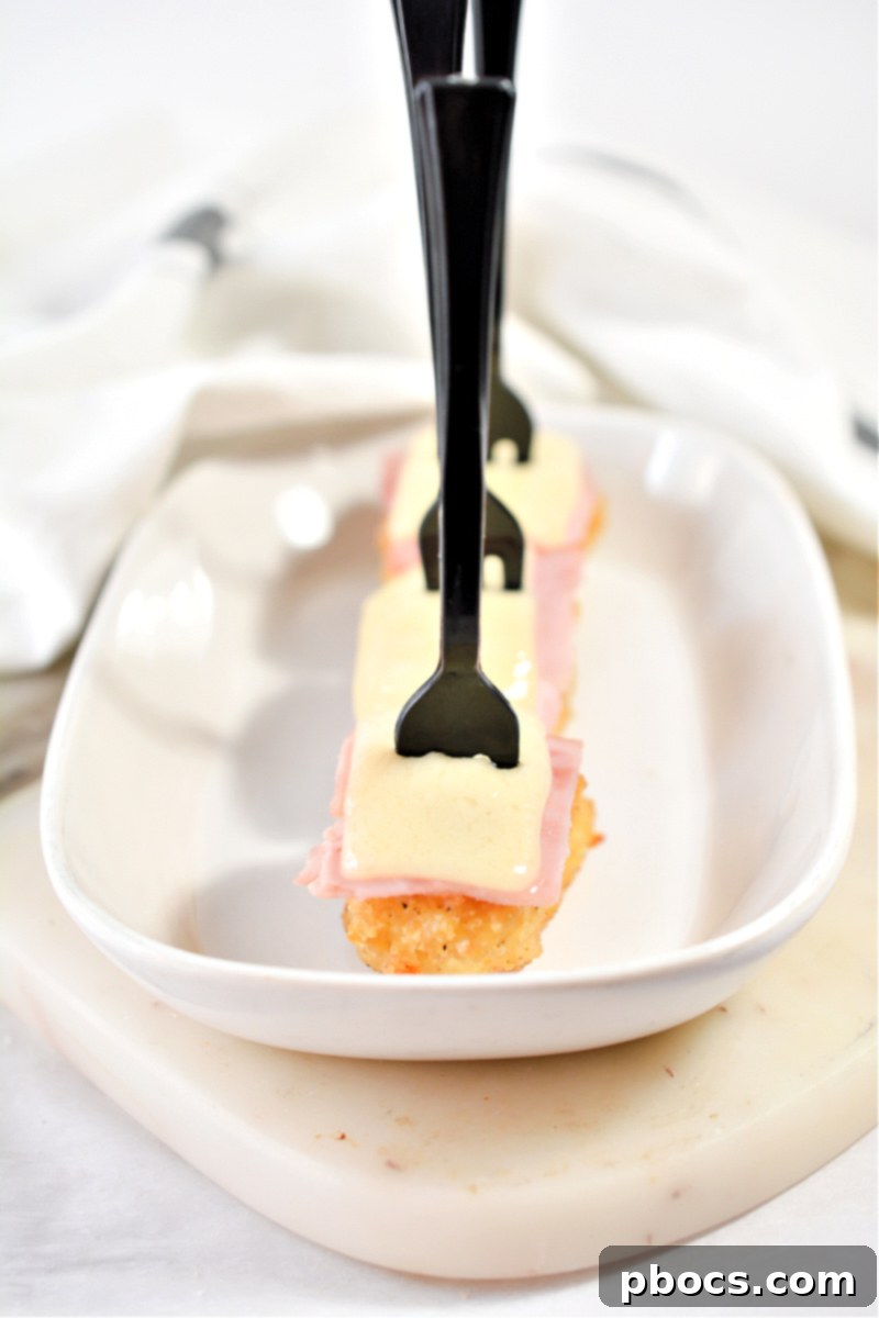 Keto Cordon Bleu Chicken Poppers 8 A single Keto Chicken Cordon Bleu Bite on a small white plate, ready to eat.