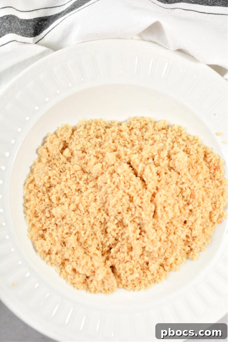 Keto Cordon Bleu Chicken Poppers 10 Step-by-step: Combining pork rind crumbs, Parmesan, garlic powder in a shallow bowl.