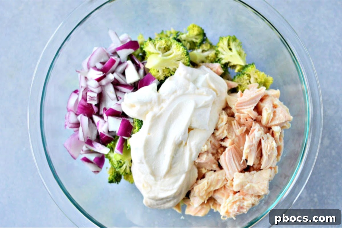 Pouring dressing over chicken and broccoli salad