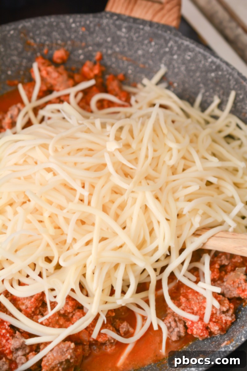 Mixing low-carb sauce and Parmesan cheese with ground beef