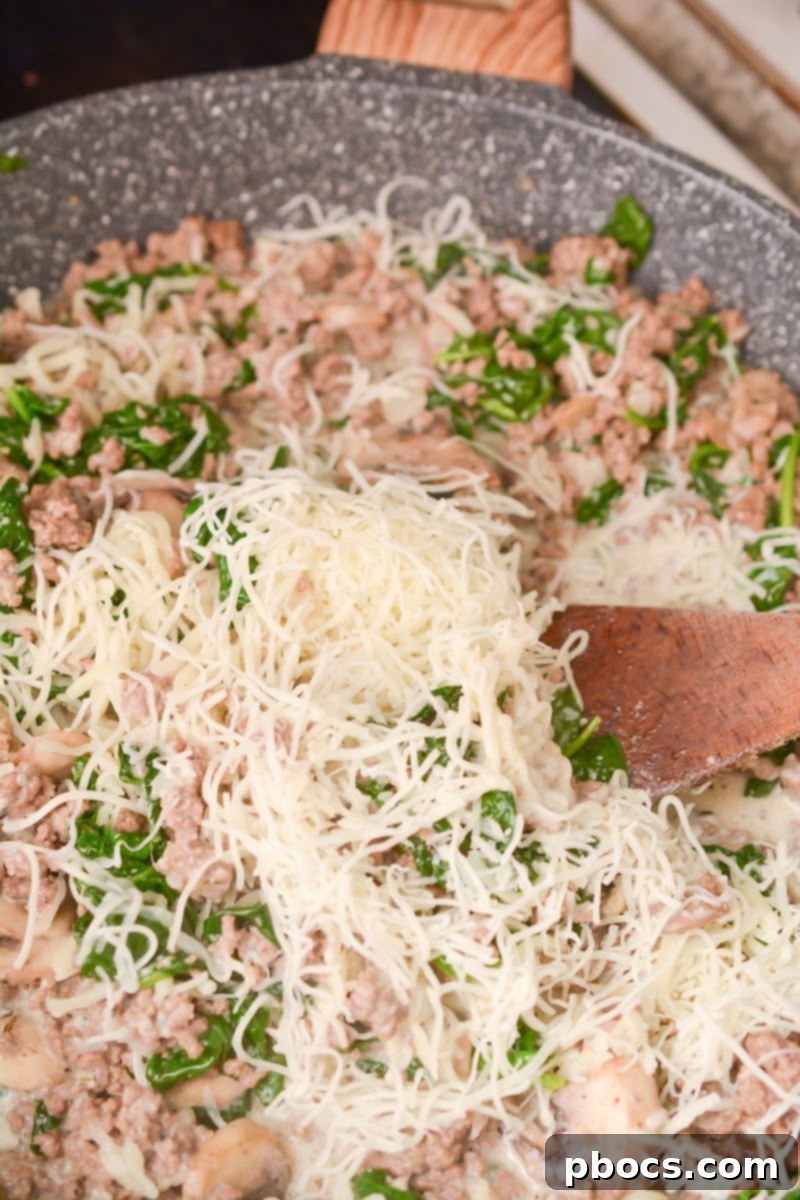 Ultimate Cheesy Keto Beef, Spinach & Mushroom Feast 12 Spinach wilting in the skillet with the beef, mushrooms, and spices.