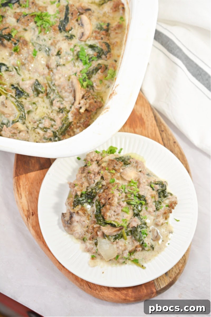 Ultimate Cheesy Keto Beef, Spinach & Mushroom Feast 7 A serving of Cheesy Keto Ground Beef Casserole with Spinach and Mushrooms, garnished with fresh parsley.