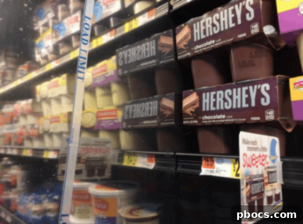 Close-up of a child drawing a pumpkin face on a painted Hershey's pudding cup with a marker