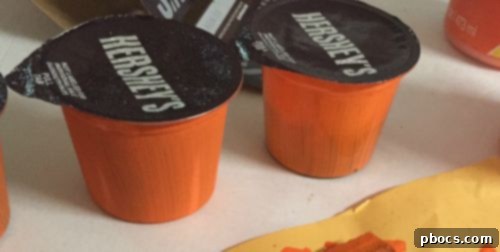 Hershey's pudding cups drying after initial paint coat, lined up neatly