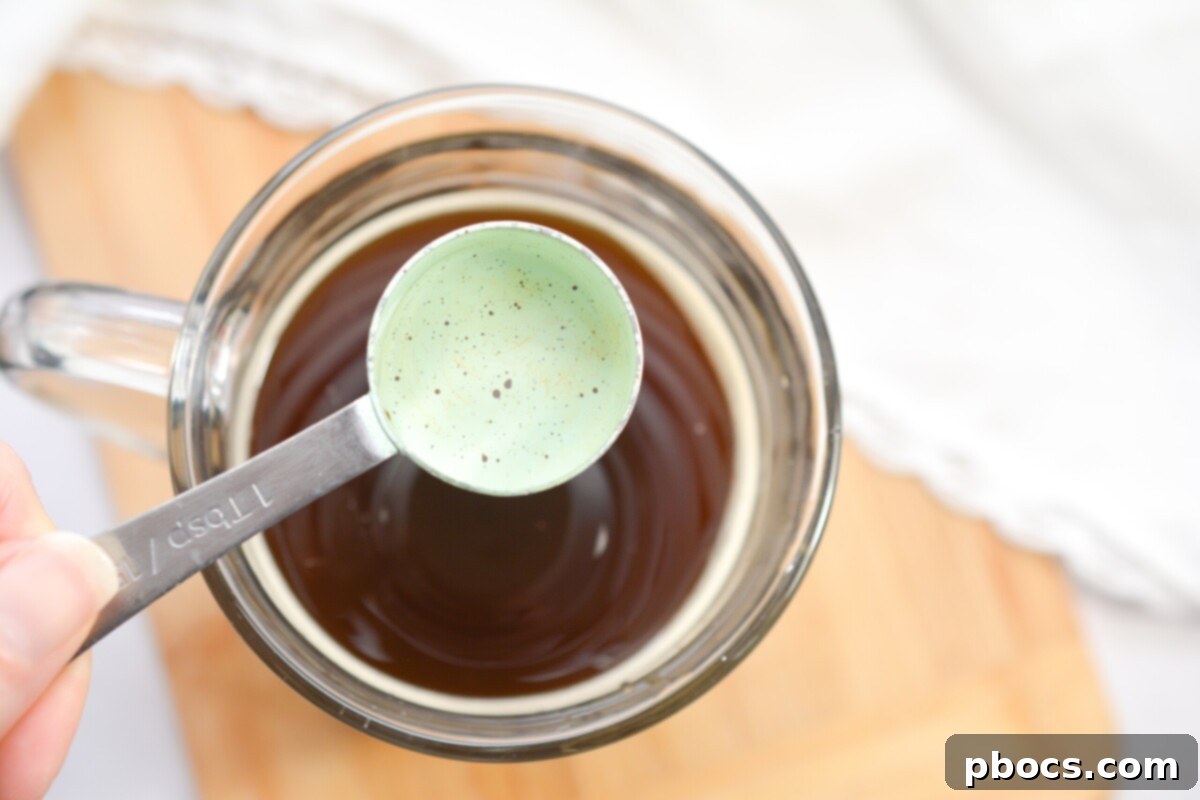 Adding sugar-free vanilla syrup to coffee base for Keto Pumpkin Cold Brew.