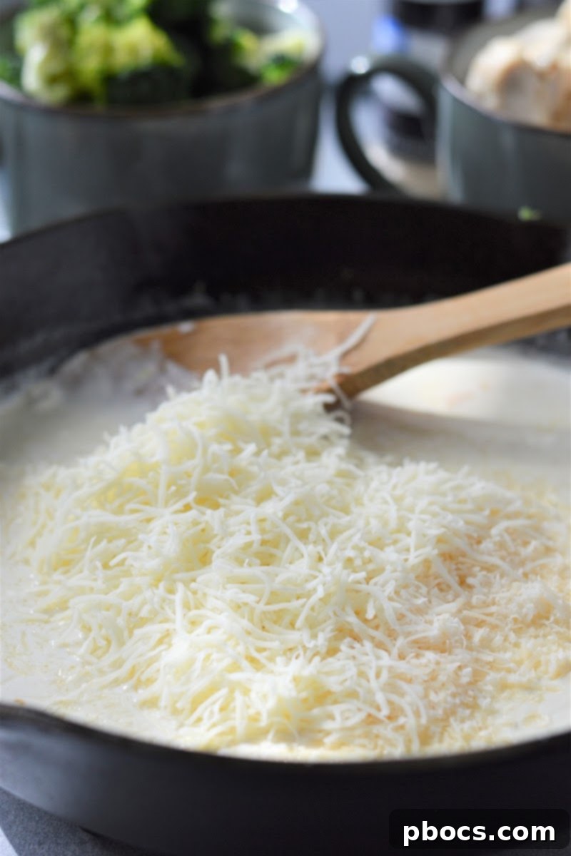 Creamy Low-Carb Chicken Alfredo 11 Cream cheese and heavy cream melting in a skillet with garlic and butter.
