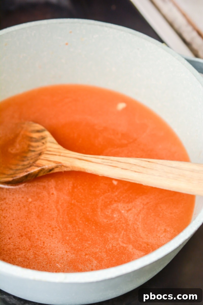 Close-up of the fragrant red curry paste mixture cooking in the pan